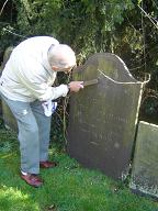 Des very painstakingly trying to make the words on Joel's headstone more legible